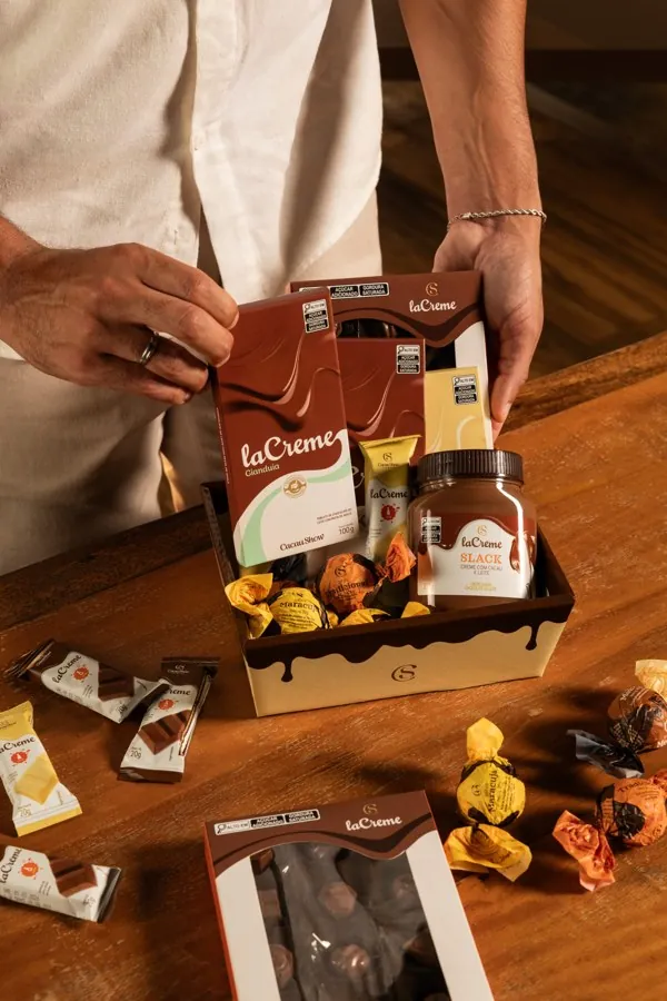 Mãos segurando uma caixa de produtos laCrème